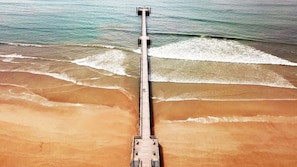 A pier extending into the ocean with a boat docked at the end.