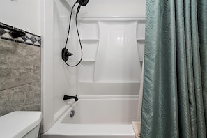 Ein Badezimmer mit Badewanne, Toilette und Duschvorhang.