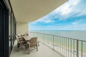 A balcony with a view of the beach and ocean.