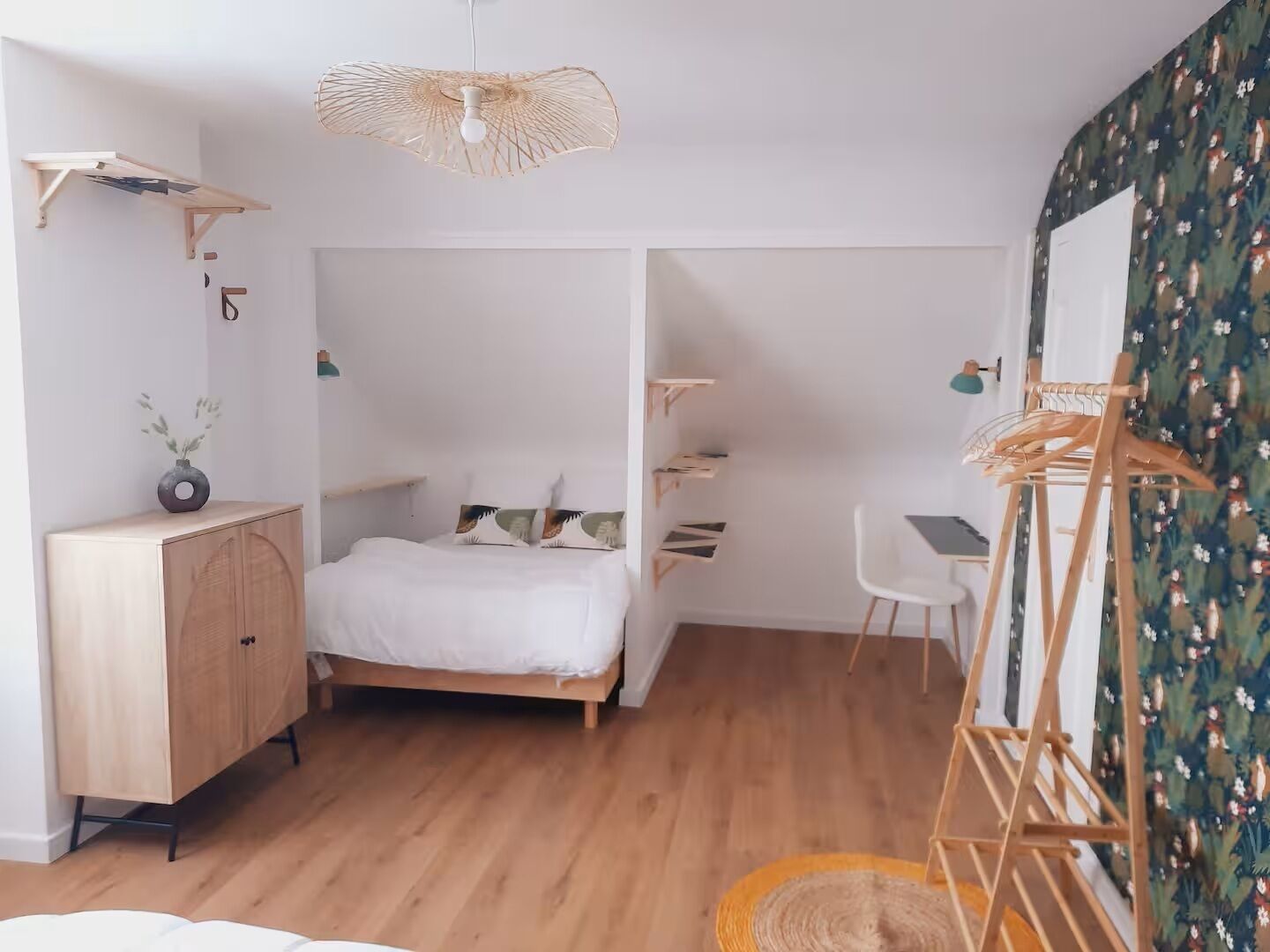 Een moderne slaapkamer met een houten bed, een bureau en een hangstoel.