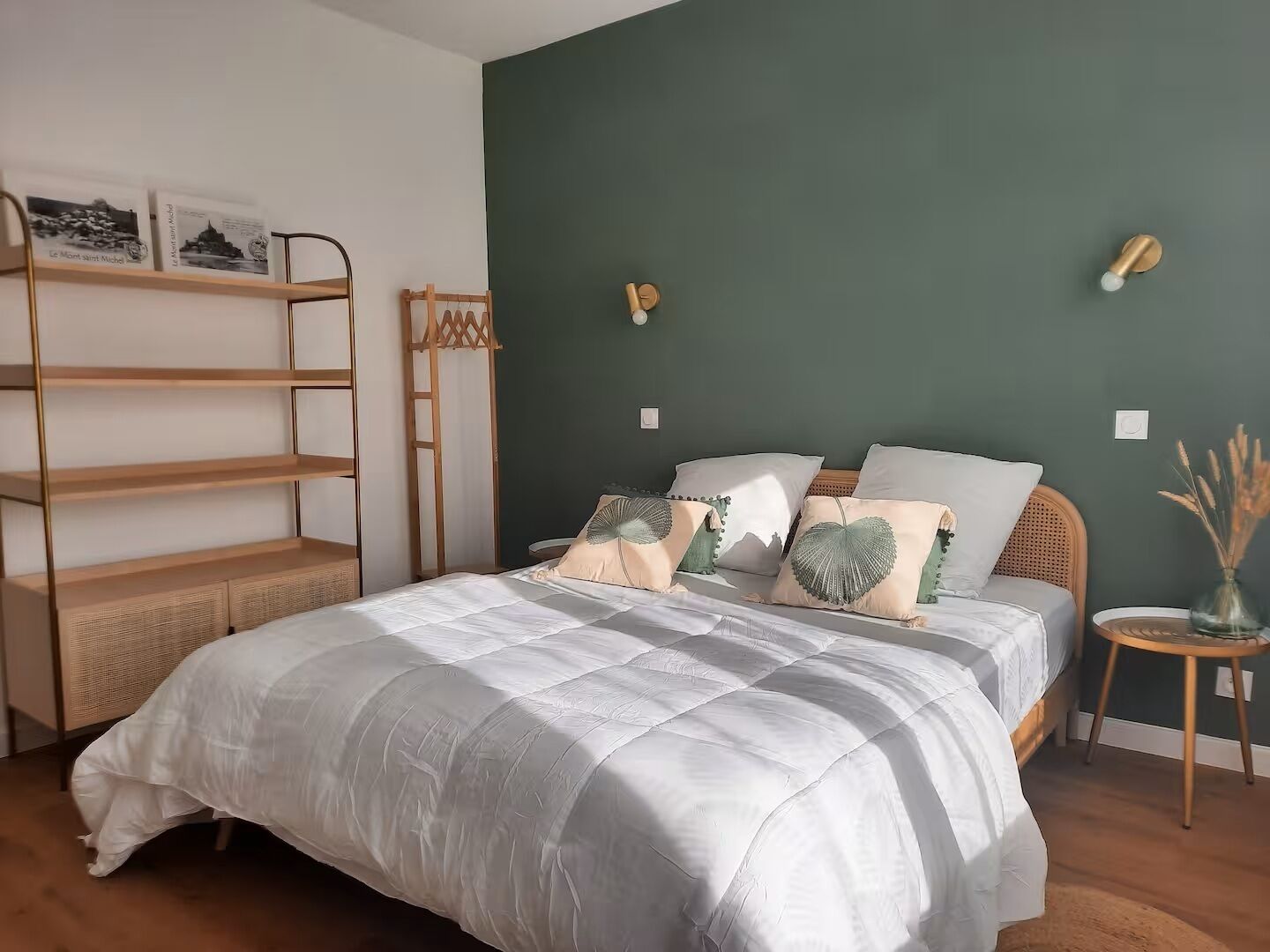 A bedroom with a bed, a wooden ladder, a shelf with books, and a small table with a vase.