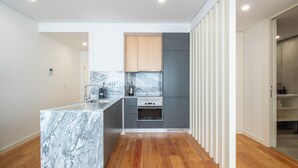 A modern kitchen with a marble countertop, wooden cabinets, and a built-in oven.