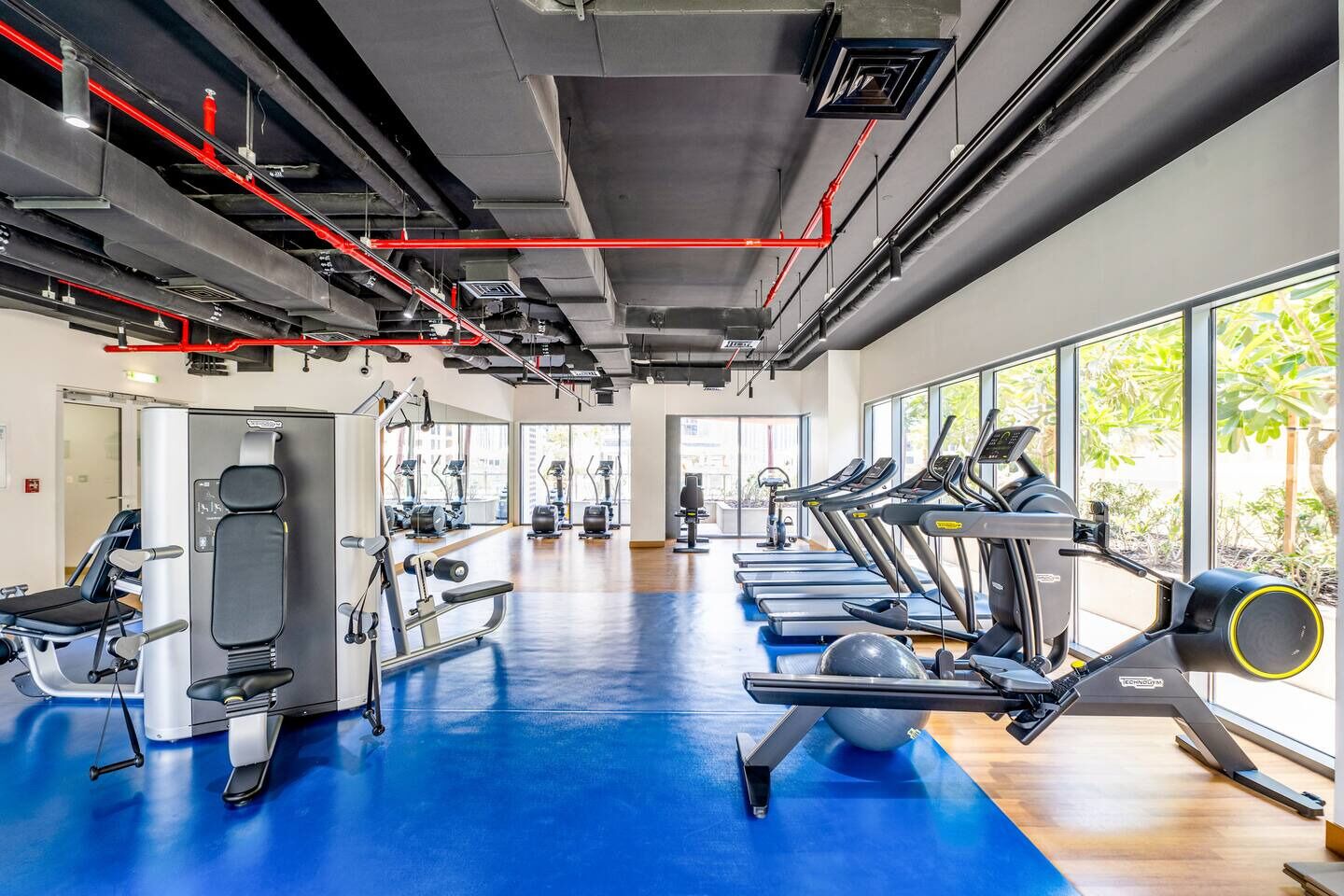 A gym with treadmills, weight machines, and exercise equipment.