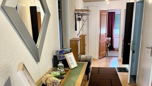 Un pasillo con mostrador de recepción, un espejo y suelo de madera.