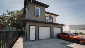 A two-story house with a garage and a car parked in front. - GarageSuite| 2BD + Ping Pong Fun (Edmonton)