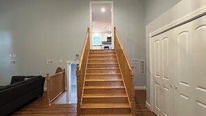 Un escalier menant à une cuisine ouverte, d  ’où l’on a vue sur le salon.