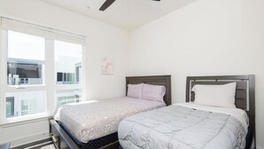 A bedroom with two beds, a ceiling fan, and a window with blinds. - 2BR Hollywood Apt w/ Rooftop deck & Stunning Views (Los Angeles)
