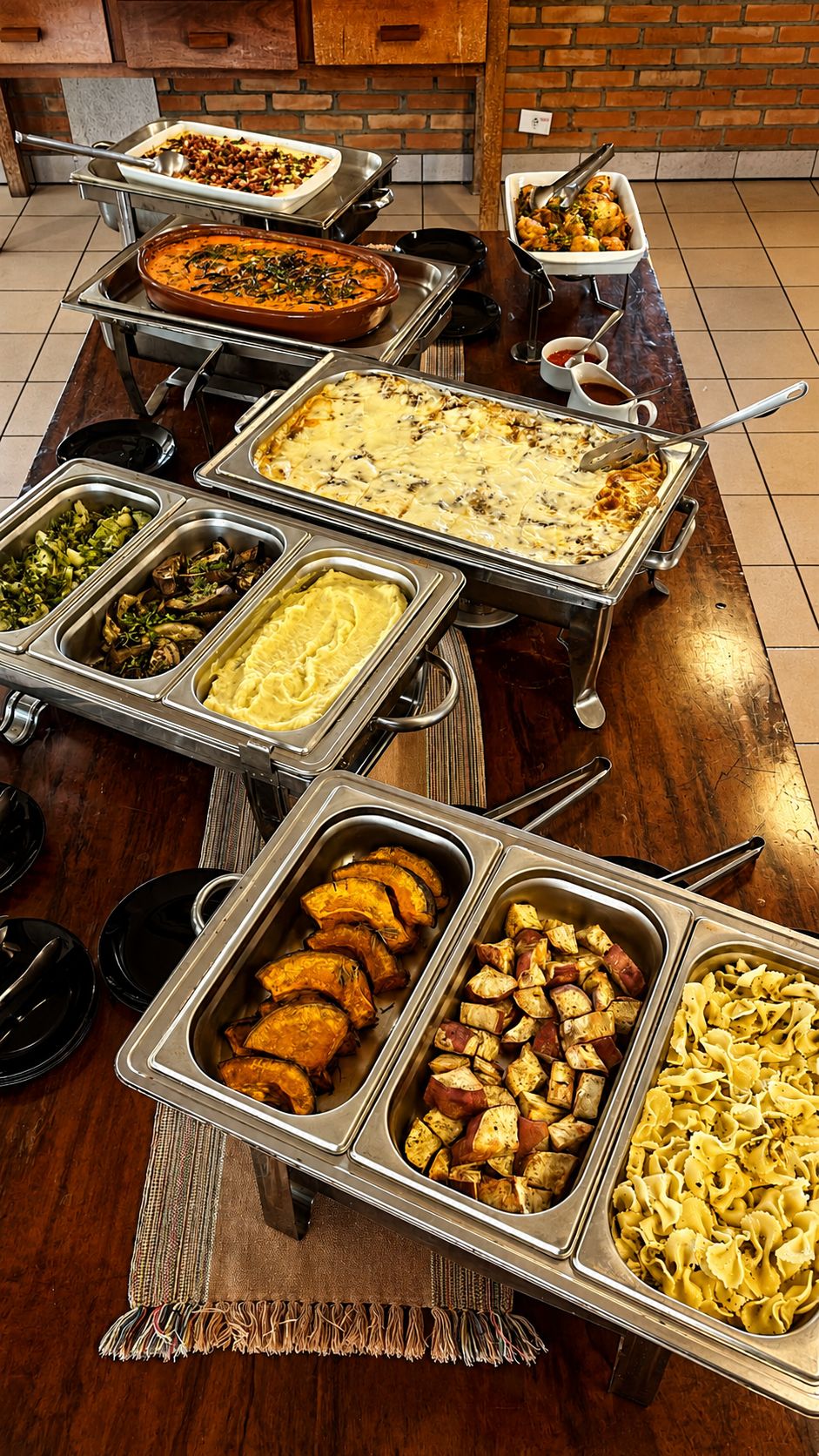 A buffet table with various dishes including casseroles, vegetables, and pasta.
