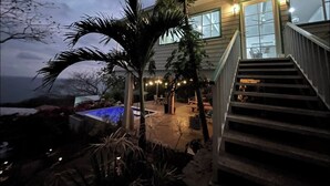 A house with a pool, stairs, and a view of the ocean.