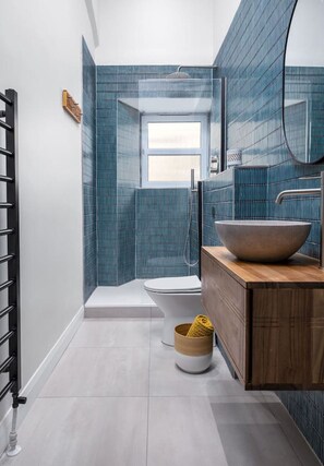 Une salle de bain moderne dotée d’une grande fenêtre, d’une baignoire et d’un meuble-lavabo en bois avec un vasque.