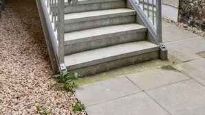 A residential building with a staircase leading to a door marked 'D'. - Stirling's Hidden & Tranquil Studio Apartment (Stirling)