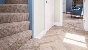 A staircase with carpeted steps leading to a room with a stone wall and a blue chair. - Craighall House, Stunning River Tay Views & Garden (Stanley)