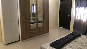 A bedroom with a bed, wardrobe, and a door.