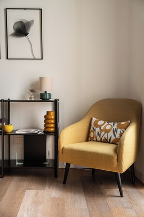 A room with a yellow armchair, a black side table with a lamp, a vase, and a framed picture on the wall. - Dimora Di Nardo, Zagara Apartment, front Ursino Castle in the heart of Catania (Catania)