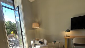 A modern living room with a sofa, a lamp, a TV, and a sliding glass door leading to an outdoor area. - Dimora Di Nardo, Zagara Apartment, front Ursino Castle in the heart of Catania (Catania)
