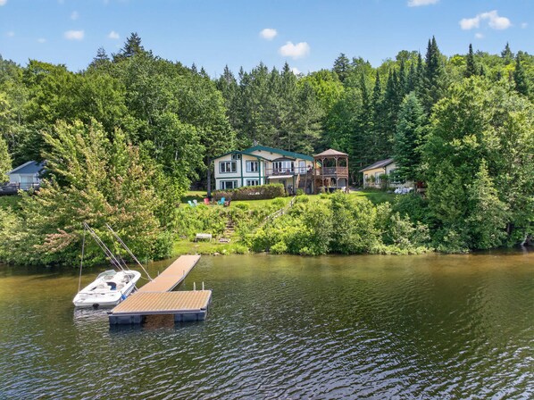 A lakeside property with a dock, a house, and a gazebo.