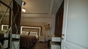 Un dormitorio con cama, mesitas de noche y un espejo.