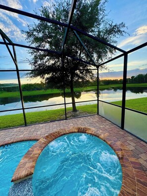 A hot tub with a view of a lake and trees.