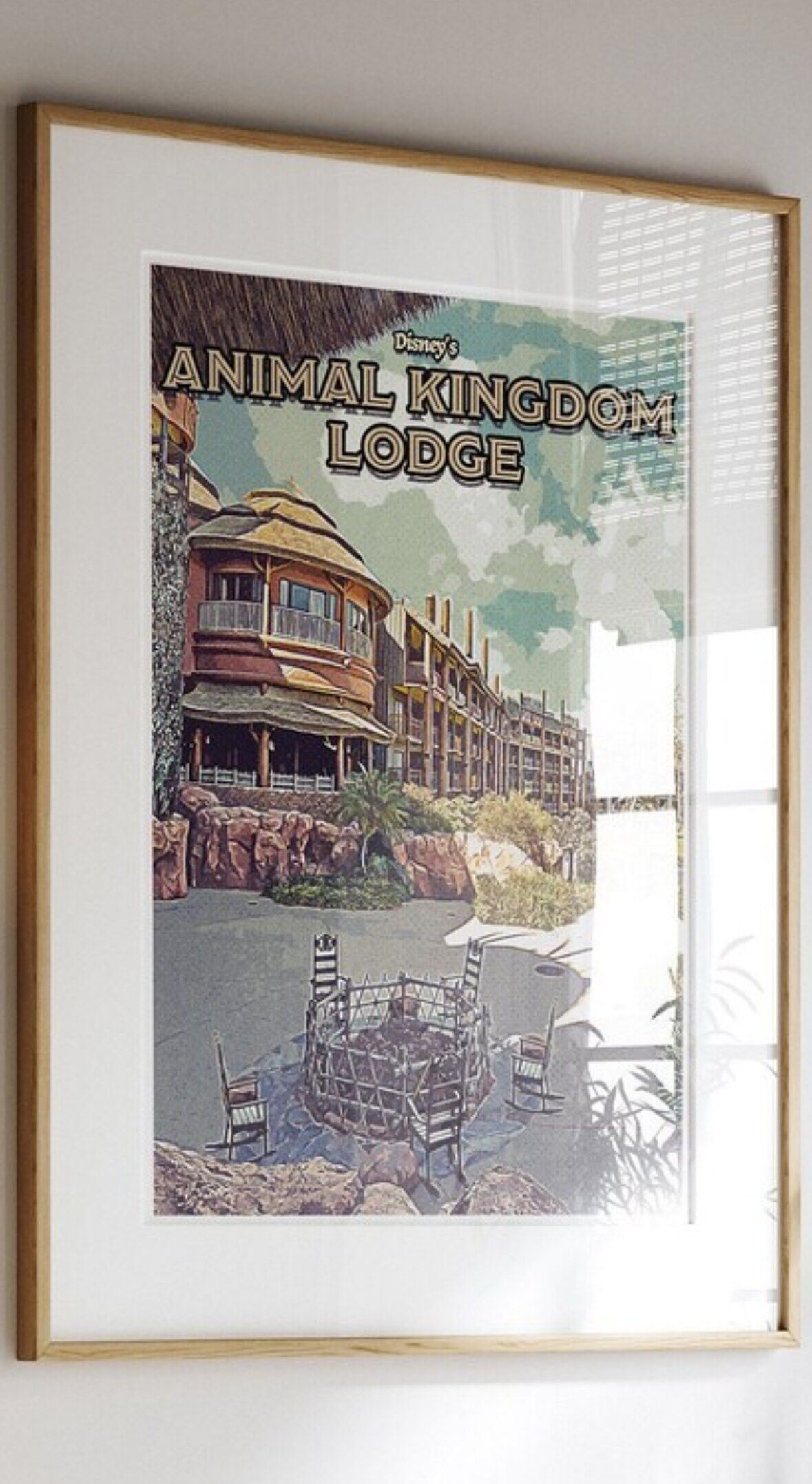 Eine gerahmte Illustration von Disneys Animal Kingdom Lodge mit einem Gebäude und einem Poolbereich.