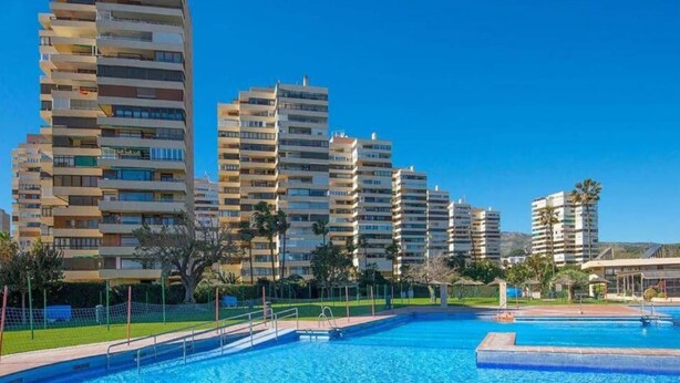 A swimming pool area with multiple high-rise buildings in the background. - Sunny Apartment Near Playamar Beach (Torremolinos)