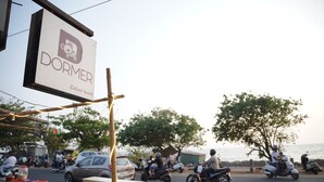 Une scène de rue avec une enseigne indiquant « Dormer Calicut Beach ».
