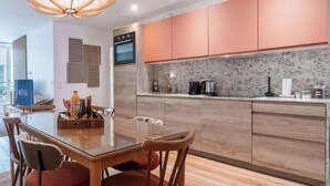 Una cocina moderna con armarios de madera, horno empotrado y encimera de granito.