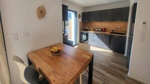 Una cocina moderna con armarios oscuros, una encimera de madera y un horno empotrado.