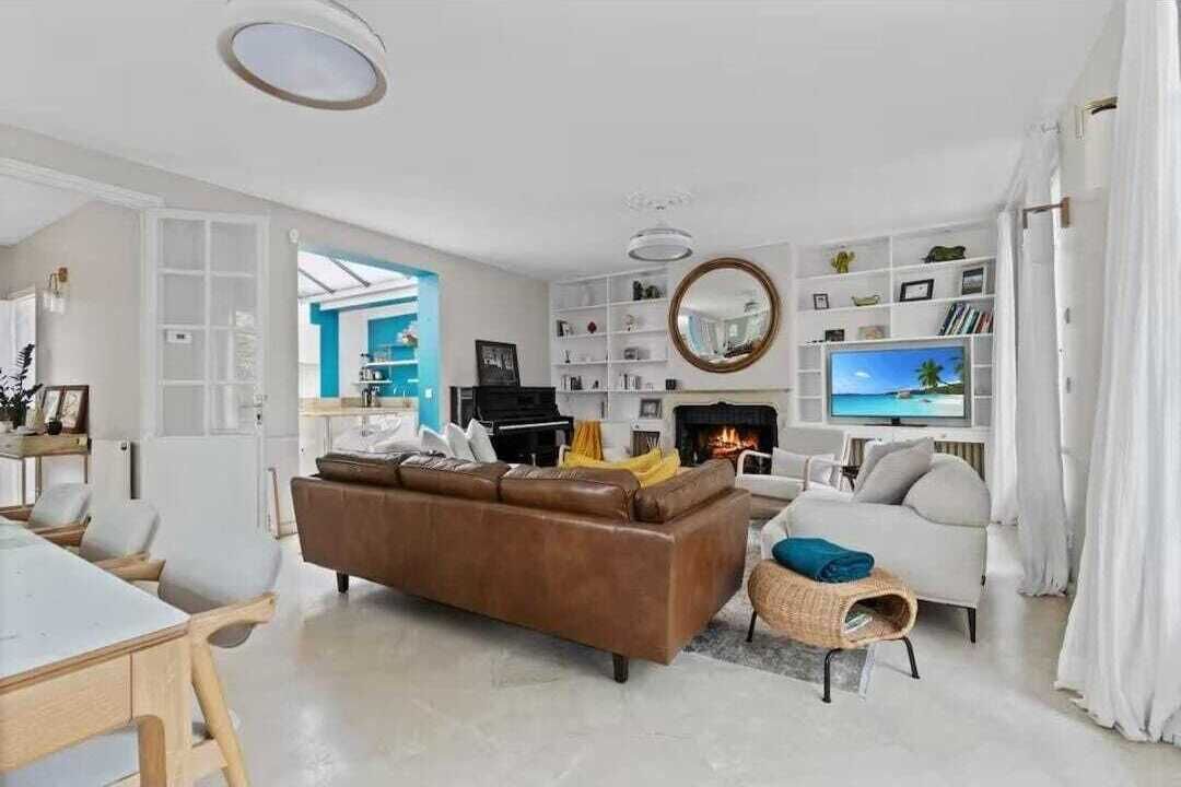 A modern living room with a fireplace, a television, and a bookshelf.