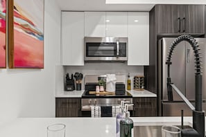 A modern kitchen with white cabinets, stainless steel appliances, and a built-in oven. - LUXE 1BR Philly Near CHOP | 15 Min to FIFA 2026 (Philadelphia)