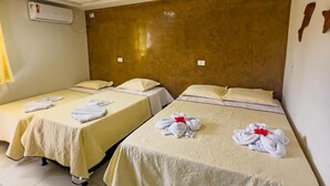 Une chambre d’hôtel avec deux lits, chacun agrémenté d’une serviette soigneusement pliée et d’un oreiller.