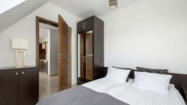 Ein Schlafzimmer mit einem Bett, einem Kleiderschrank und einem Spiegel.