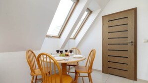 Ein Essbereich mit einem runden Tisch, vier Holzstühlen und einer Holztür.