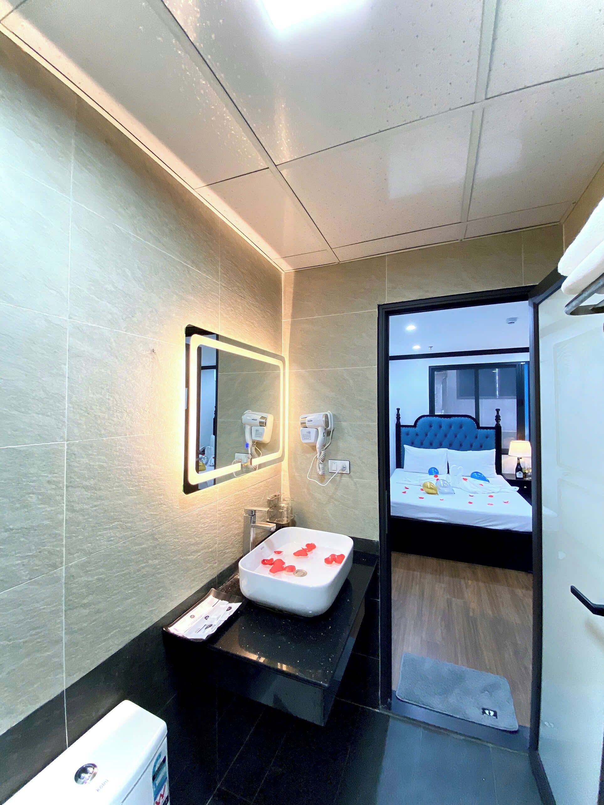 A modern bathroom with a large mirror, a sink, and a hairdryer.