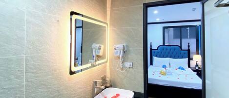 A modern bathroom with a large mirror, a sink, and a hairdryer.