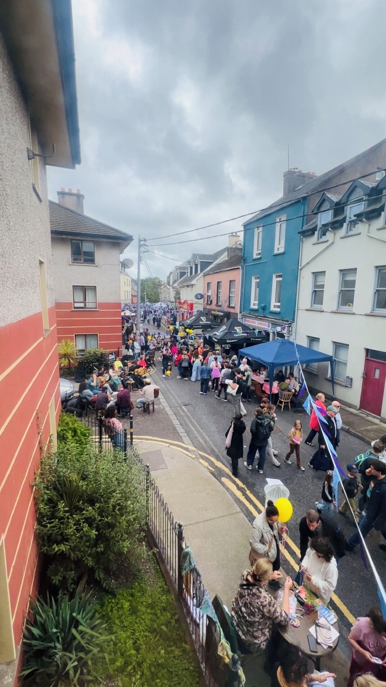Calle concurrida con gente y carpas, probablemente un mercado o festival.