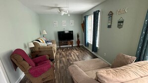 A living room with a beige sofa, a brown armchair, a TV, and a ceiling fan. - R&R Retreat w/Lake Access. Grand Lake Grove, OK (Wyandotte)