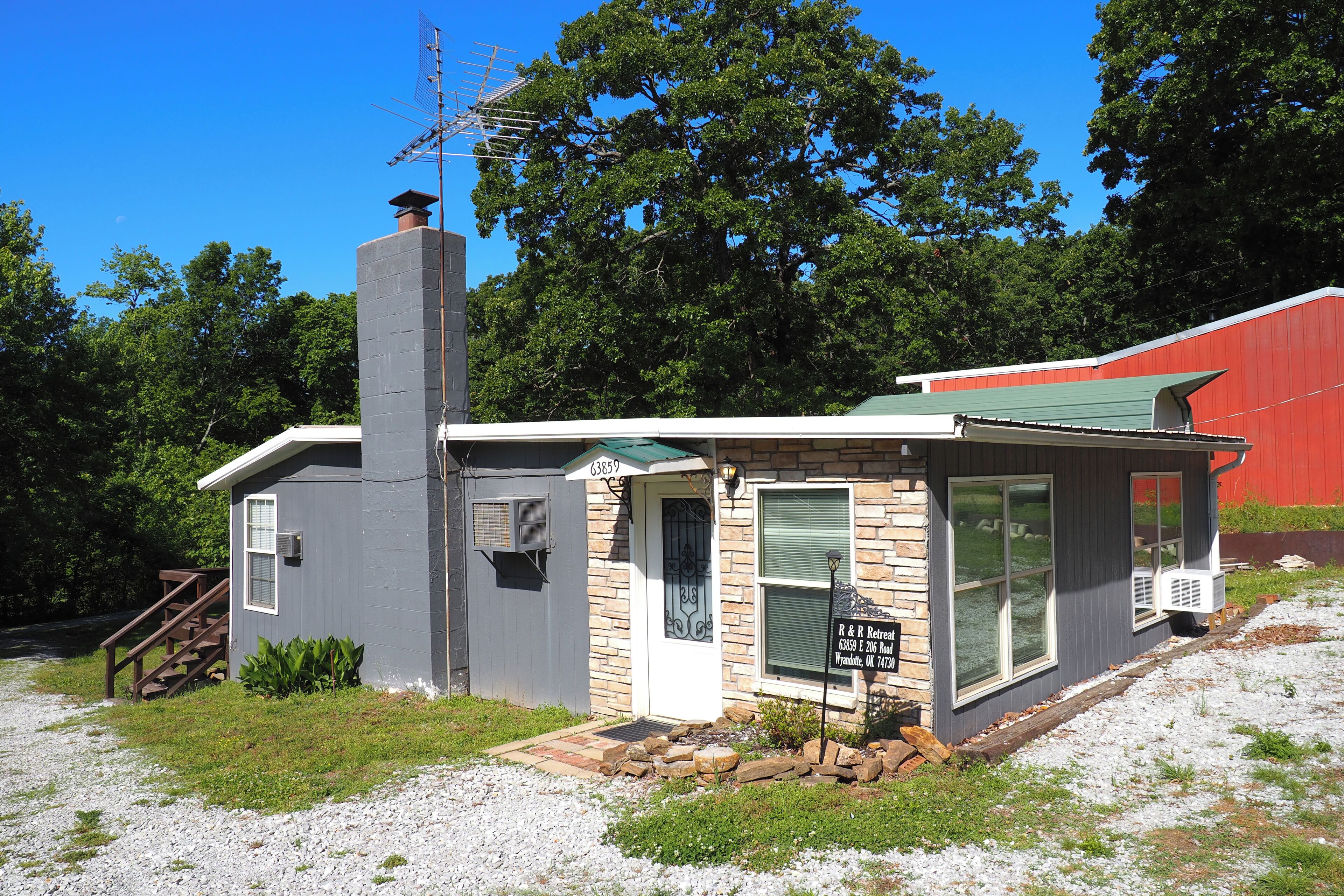 A small, single-story building with a chimney, a front door, and a signboard.