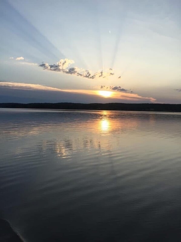 Un lago tranquilo al atardecer, bajo un cielo despejado.