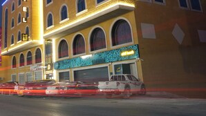 A hotel with a prominent 'HOTEL' sign, multiple arched windows, and a neon sign indicating a restaurant. - AWTAR DAHAB HOTEL  (Ma'an)