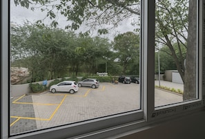 A parking area with cars, trees, and a sign that reads "Courtside Data Kiosk."