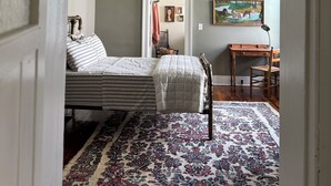 A bedroom with a bed, a desk, a chair, a ceiling fan, and a rug. - Charming Retreat steps from the Erie Canal (Albion)