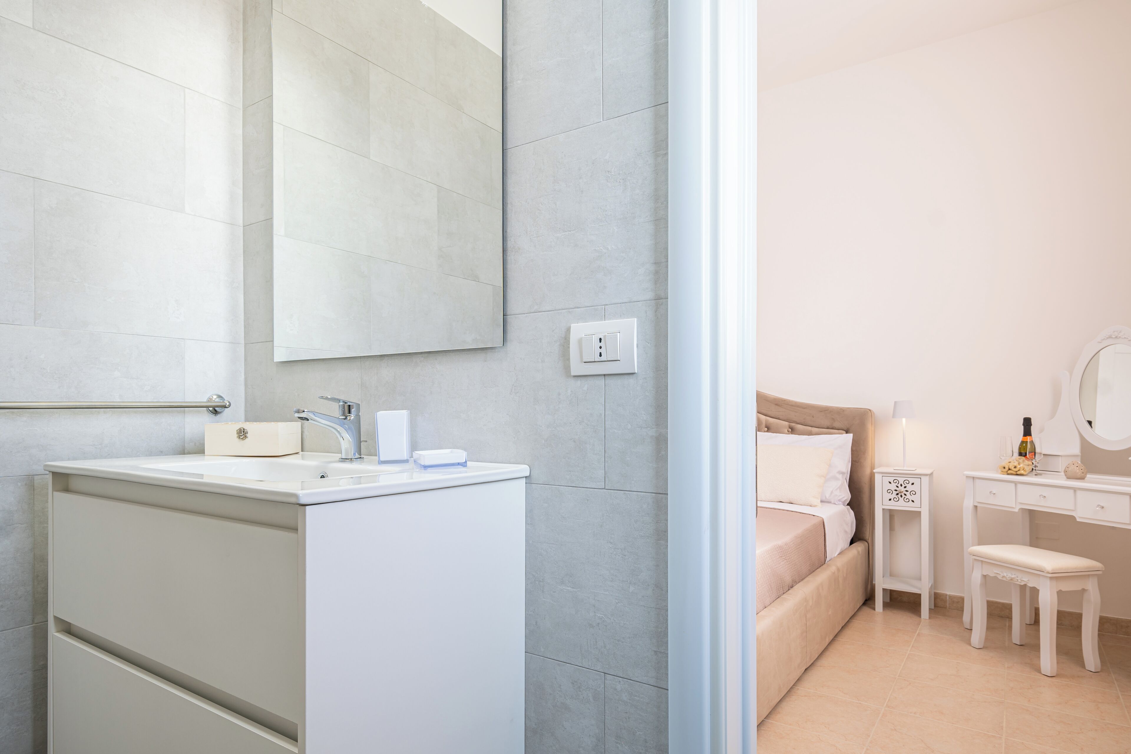 Ein modernes Badezimmer mit einem großen Spiegel, einem Waschbecken und einer Toilette.