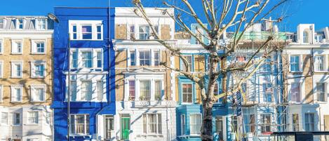 A row of terraced houses with a tree in the foreground.