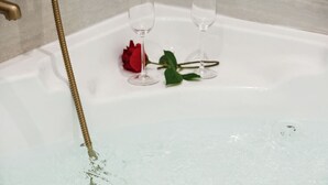A bathtub with two wine glasses and a red rose. - Central Bordeaux Gem AC Jacuzzi (Bordeaux)