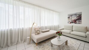 Ein modernes Wohnzimmer mit einer Couch, einem Couchtisch und einer Lampe.