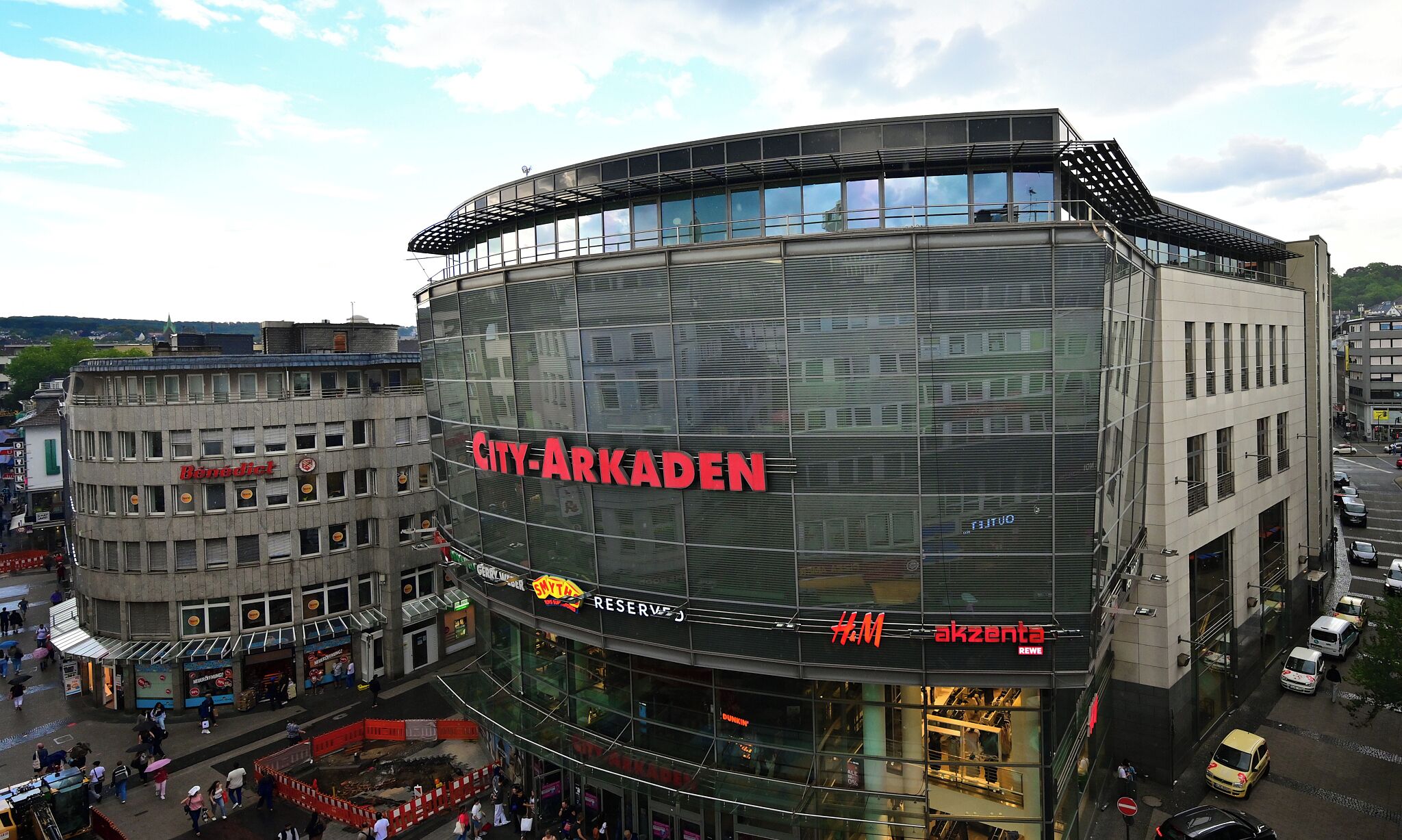Un edificio moderno con fachada de vidrio que muestra claramente el nombre 'CITY-ARKADEN'.