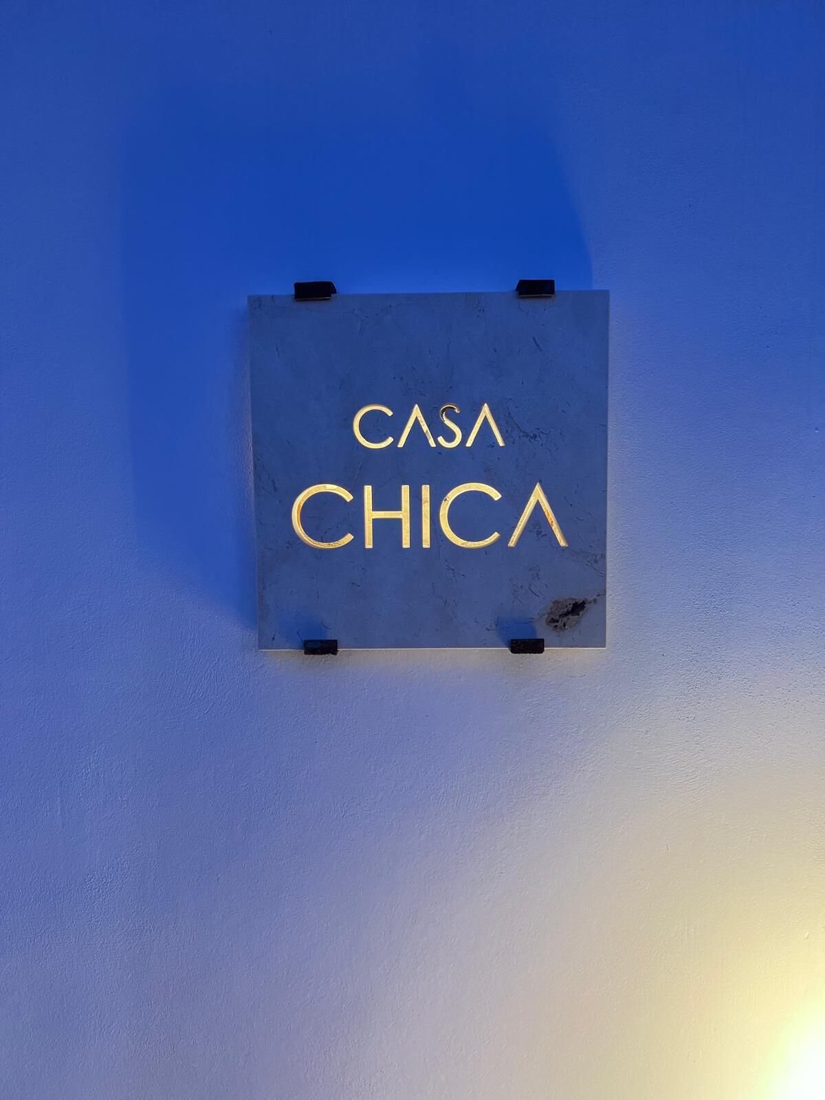 A sign with the text "CASA CHICA" mounted on a wall.