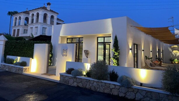 A modern house with a stone facade, large windows, and a well-lit entrance.