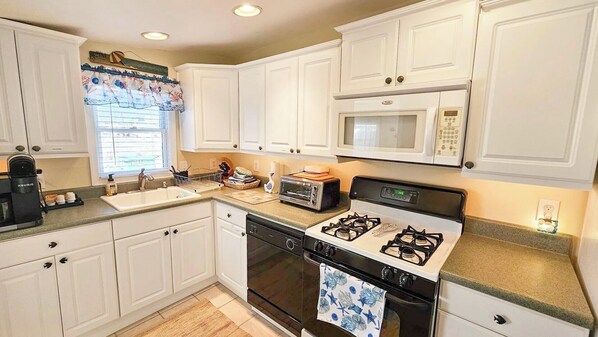 A kitchen with white cabinets, a microwave, a toaster, a stove, and a sink. - Tranquil Water View 3-bedroom, 1-bathroom house in Tuckerton
Sleeps : 8 (Tuckerton)