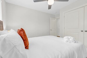 Ein Hotelzimmer mit einem Bett, einem Deckenventilator und einer Tür.